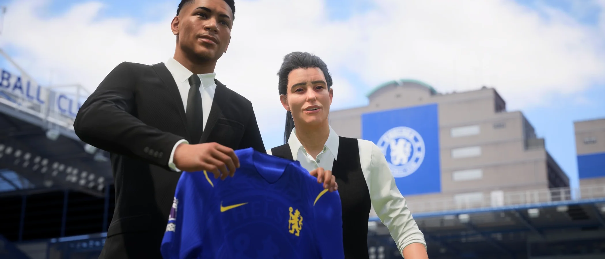 An EA SPORTS FC 27 player and club representative hold up a blue Chelsea shirt during a signing presentation.