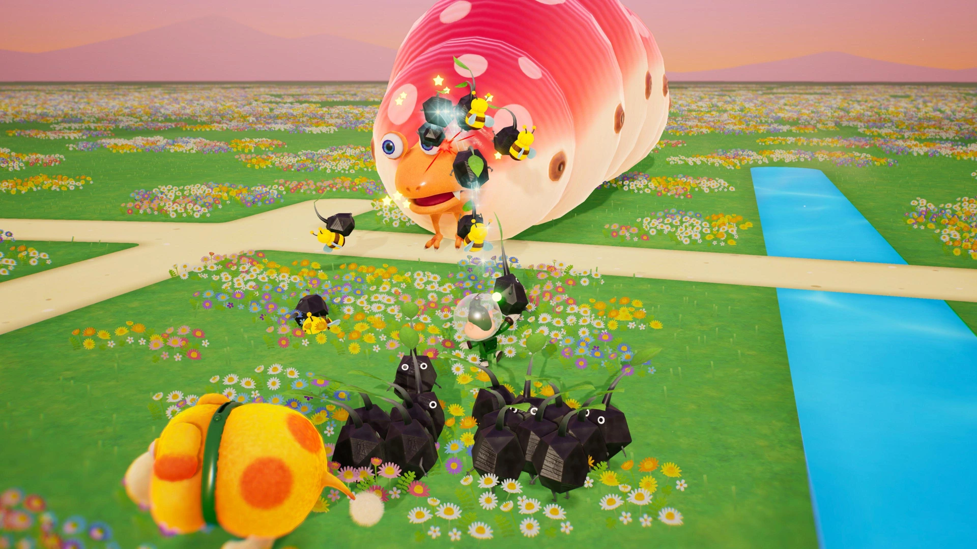 Oatchi and Pikmin face a large red-spotted creature beside paths through a flower-filled stage.