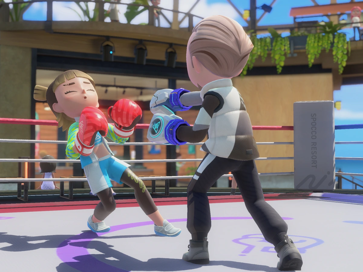 Two characters wearing boxing gloves face each other in an outdoor Resort ring.