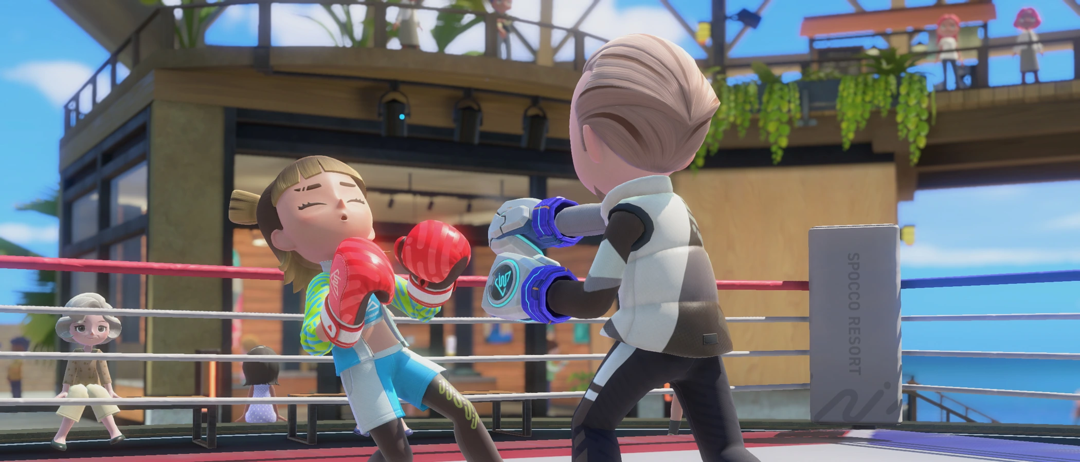 Two characters wearing boxing gloves face each other in an outdoor Resort ring.