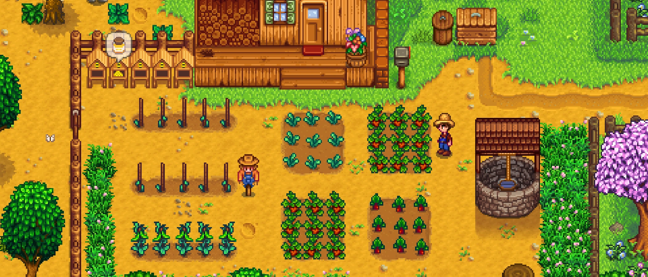 A farmer stands among crops, scarecrows and buildings on a Stardew Valley farm