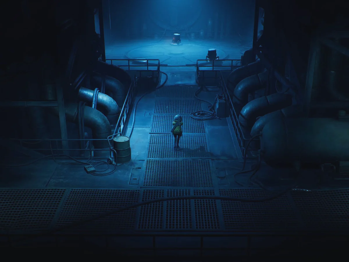 Cel stands on a grated walkway between large pipes in a dark blue industrial chamber