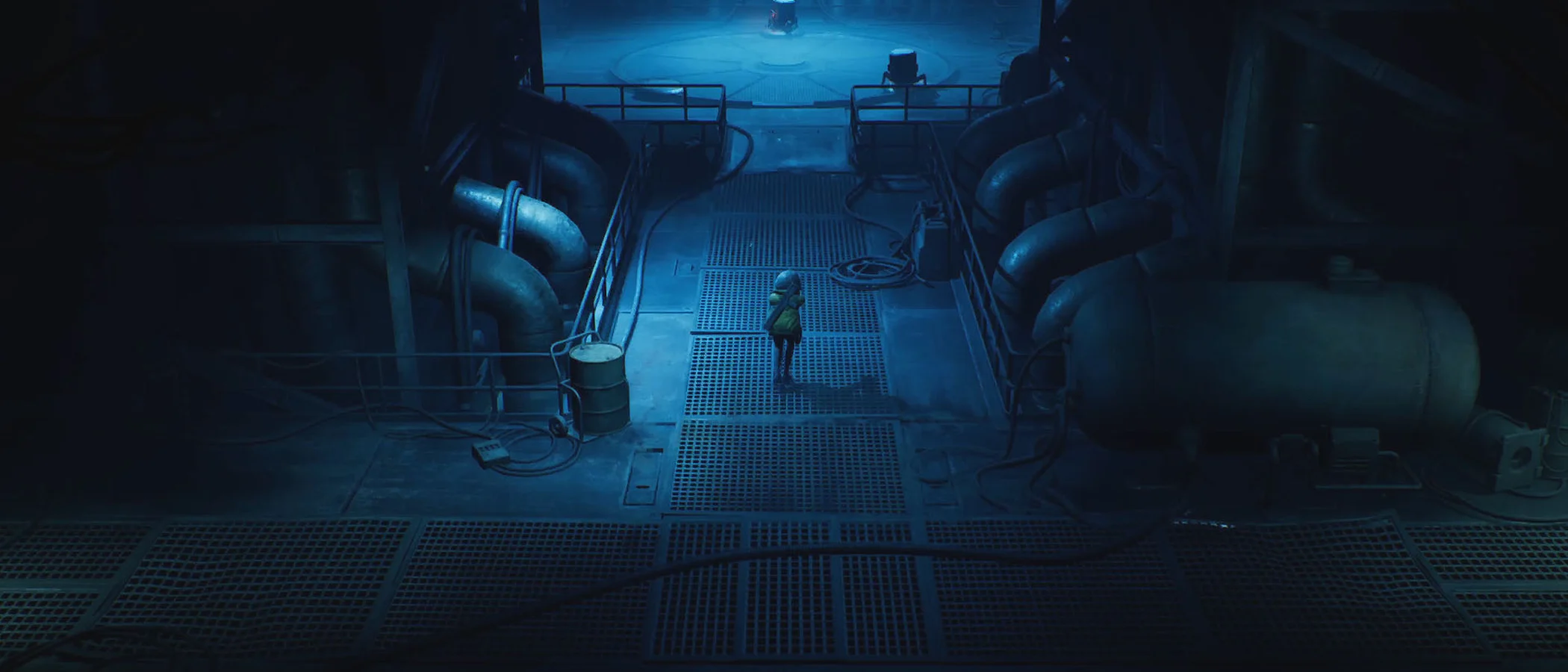 Cel stands on a grated walkway between large pipes in a dark blue industrial chamber