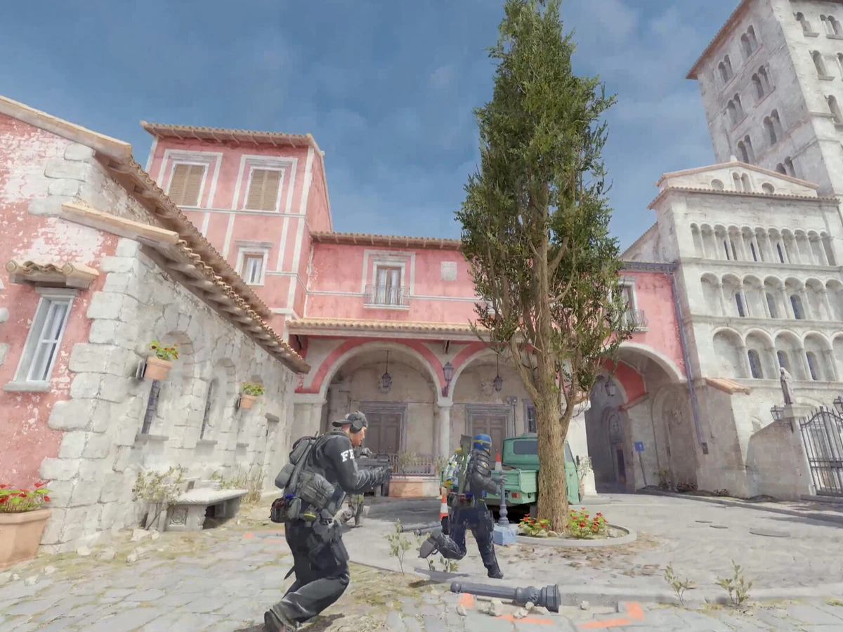Two Counter-Strike 2 teammates moving through a sunlit courtyard