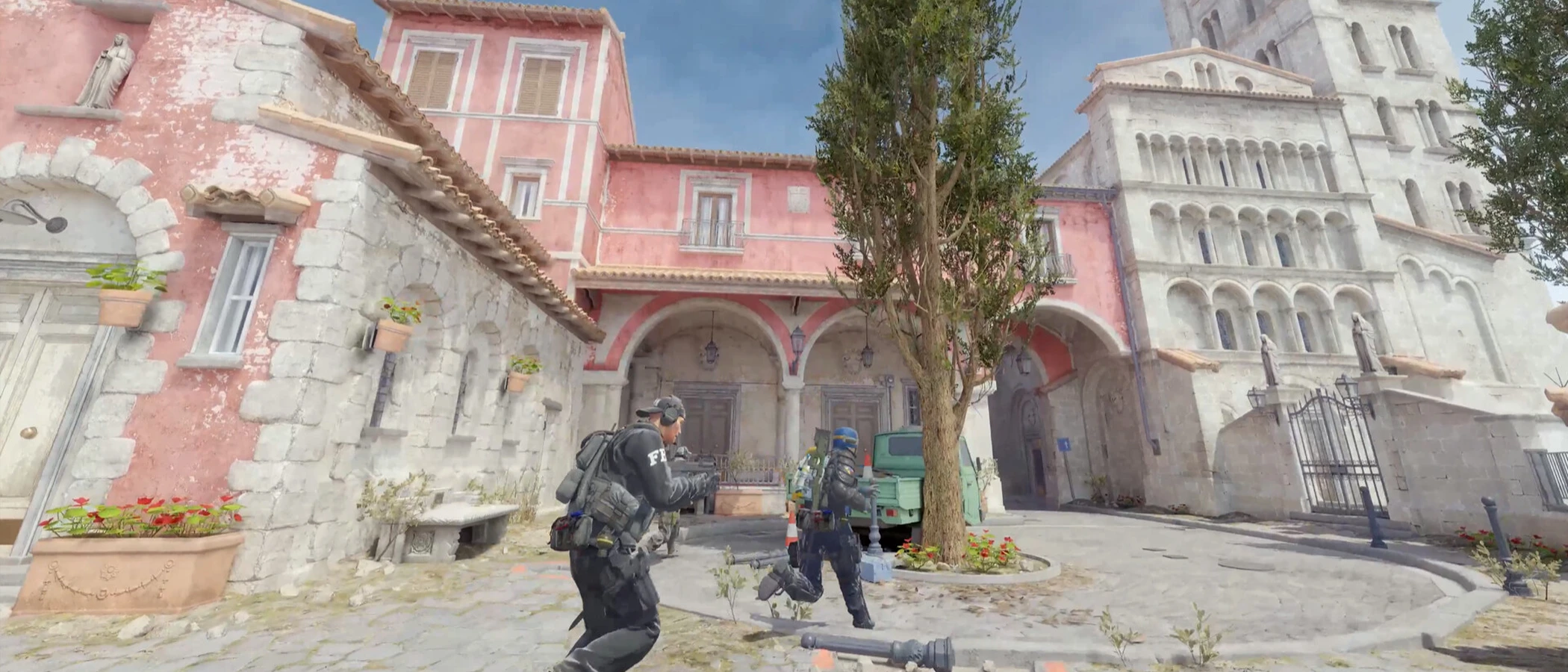 Two Counter-Strike 2 teammates moving through a sunlit courtyard