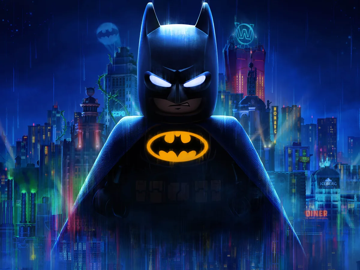 LEGO Batman stands before Gotham's skyline beneath a bright bat signal.