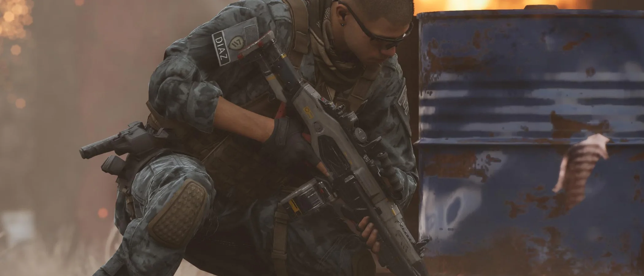 MindsEye protagonist Jacob Diaz crouches beside a barrel amid flames
