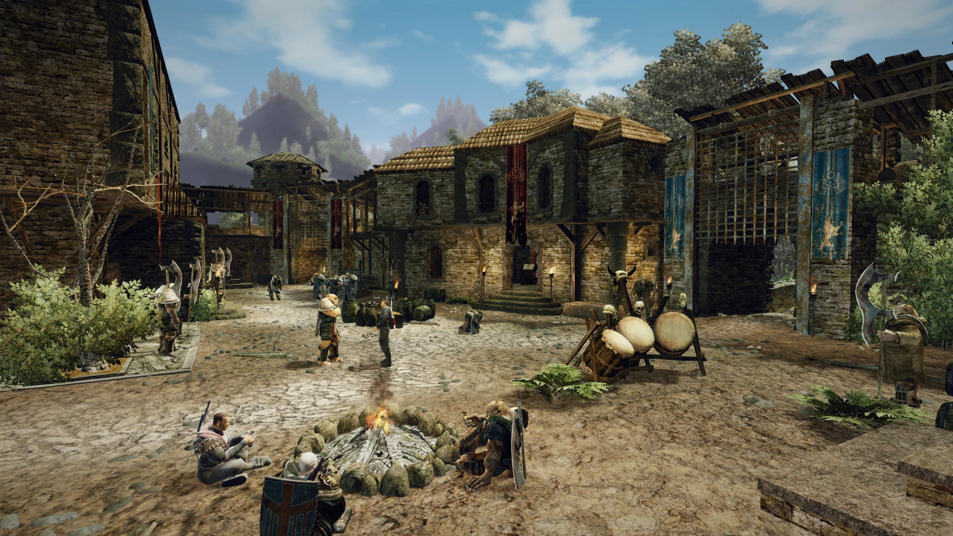 People gather around a fire in a stone courtyard with blue banners, wooden gates and archery targets.