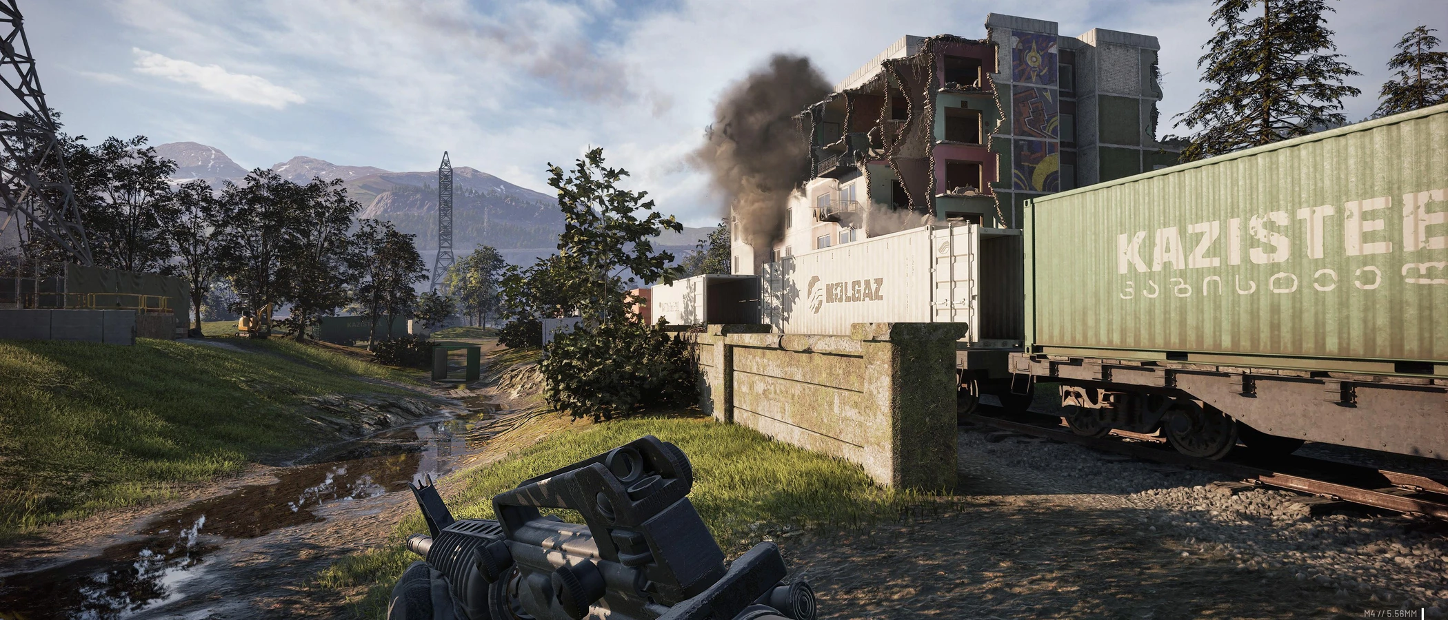 A WARDOGS soldier aims a rifle towards a damaged industrial building beneath a plume of smoke.