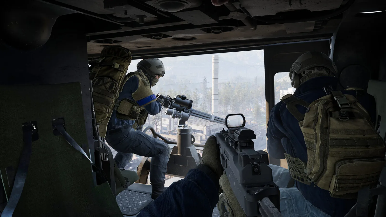 Two armed WARDOGS soldiers ride in a helicopter as another operates a mounted weapon.