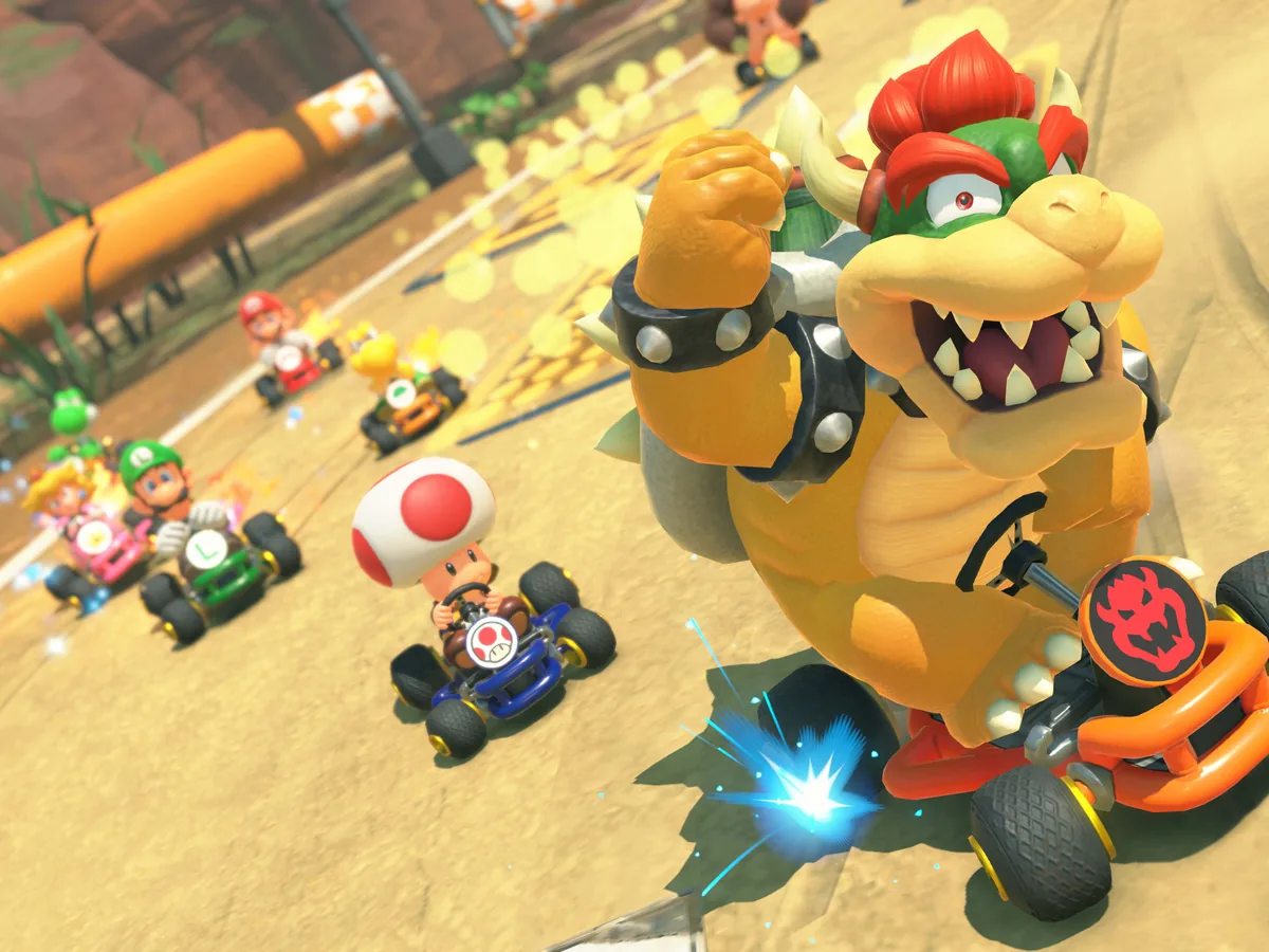 Bowser races through a sandy Super Mario Kart-inspired Choco Island course in Mario Kart World.