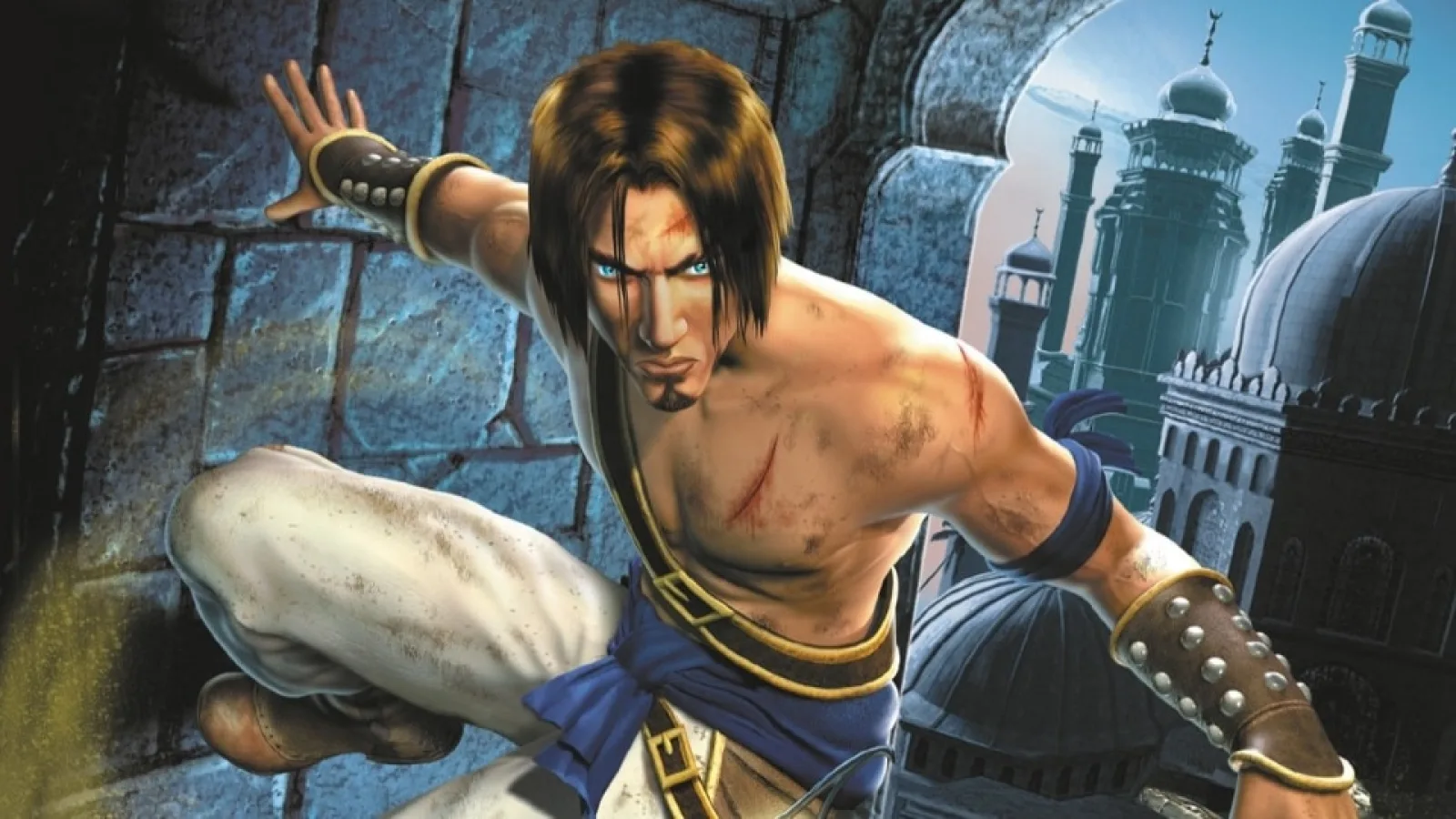 The Prince crouches against the blue stonework and towers of Azad in Prince of Persia: The Sands of Time.