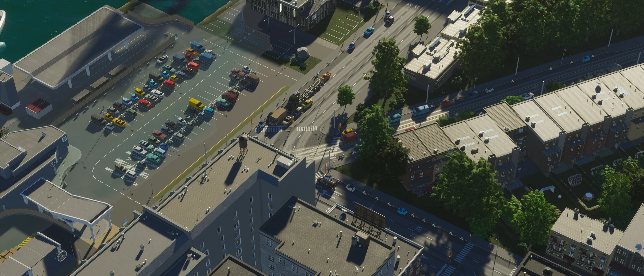 An official Cities Skylines II screenshot of streets and buildings beside a waterfront