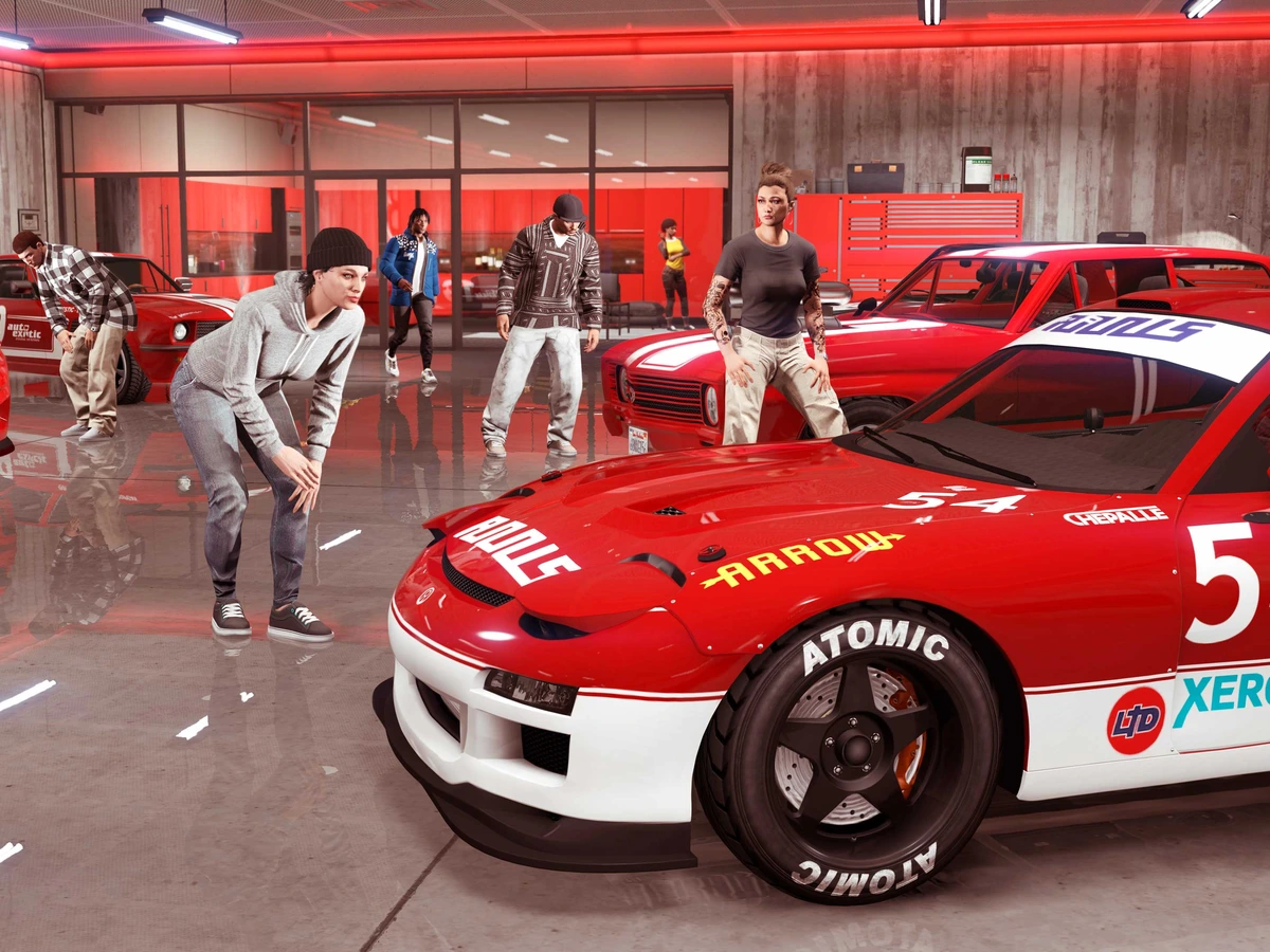 Players gather around red racing cars stored inside a GTA Online garage.