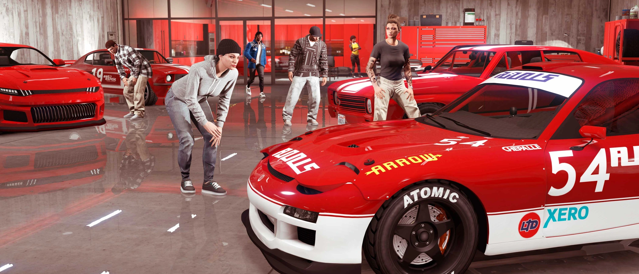 Players gather around red racing cars stored inside a GTA Online garage.