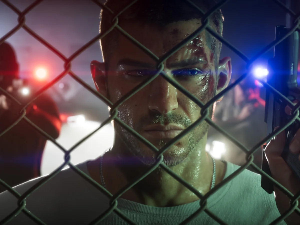 Jason Duval holds a pistol beside a chain-link fence, with police lights behind him.