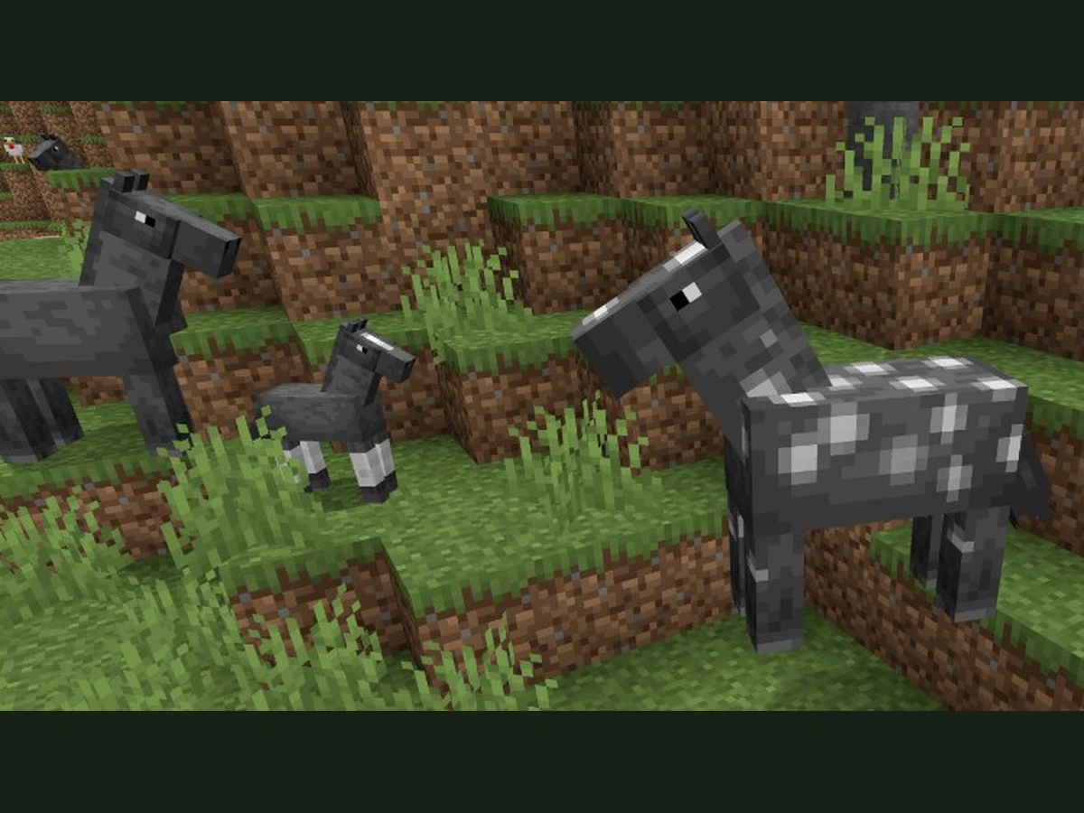 Minecraft horses stand together on grass beside a young foal
