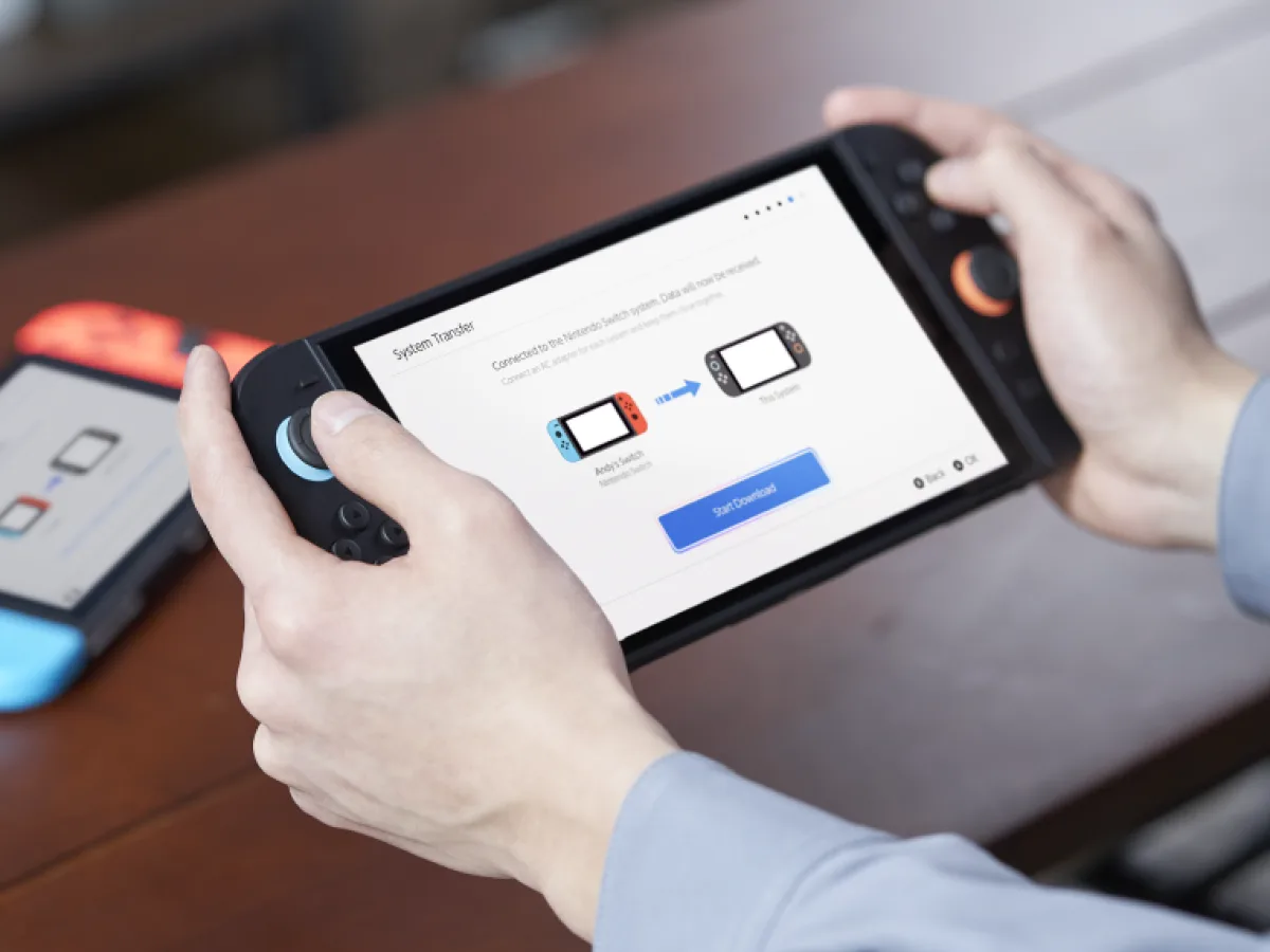 Two Nintendo Switch consoles display the system transfer setup screen on a table.