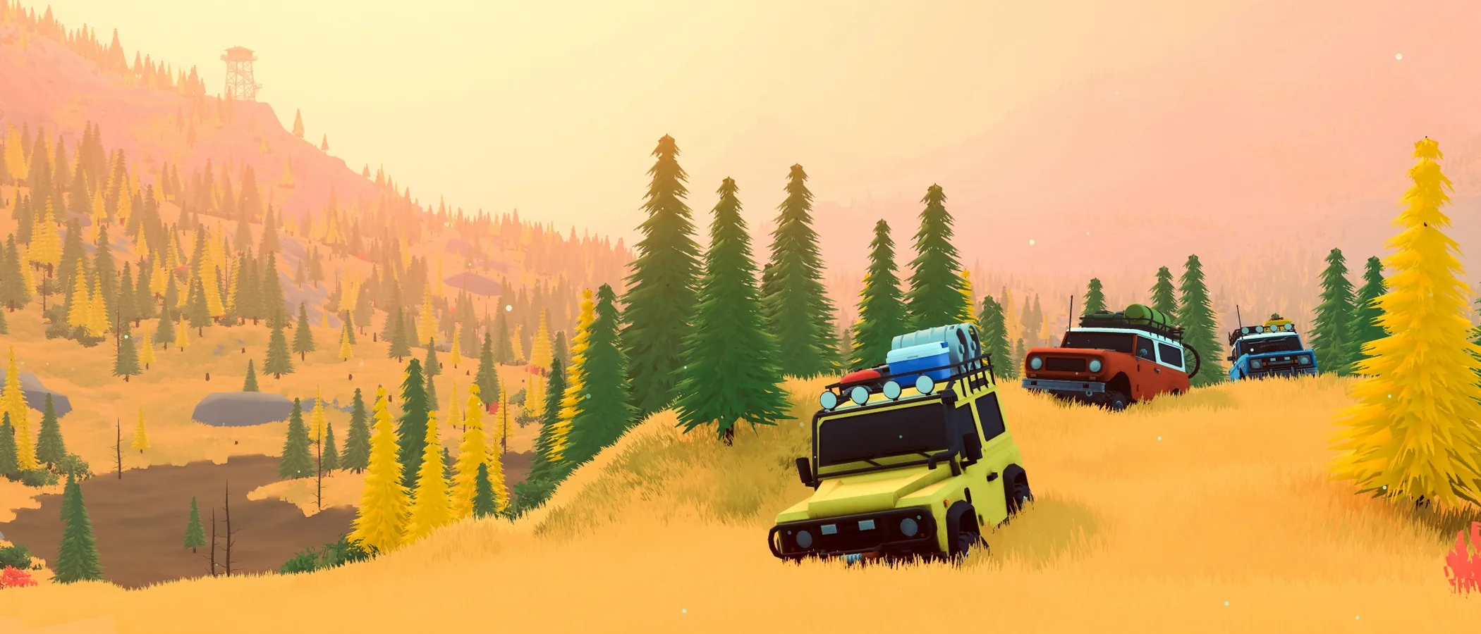Four off-road vehicles descend a grassy slope in over the hill