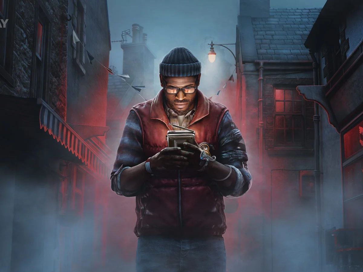 Simon stands in a misty St. Amelia street looking down at a handheld device in Silent Hill: Townfall.