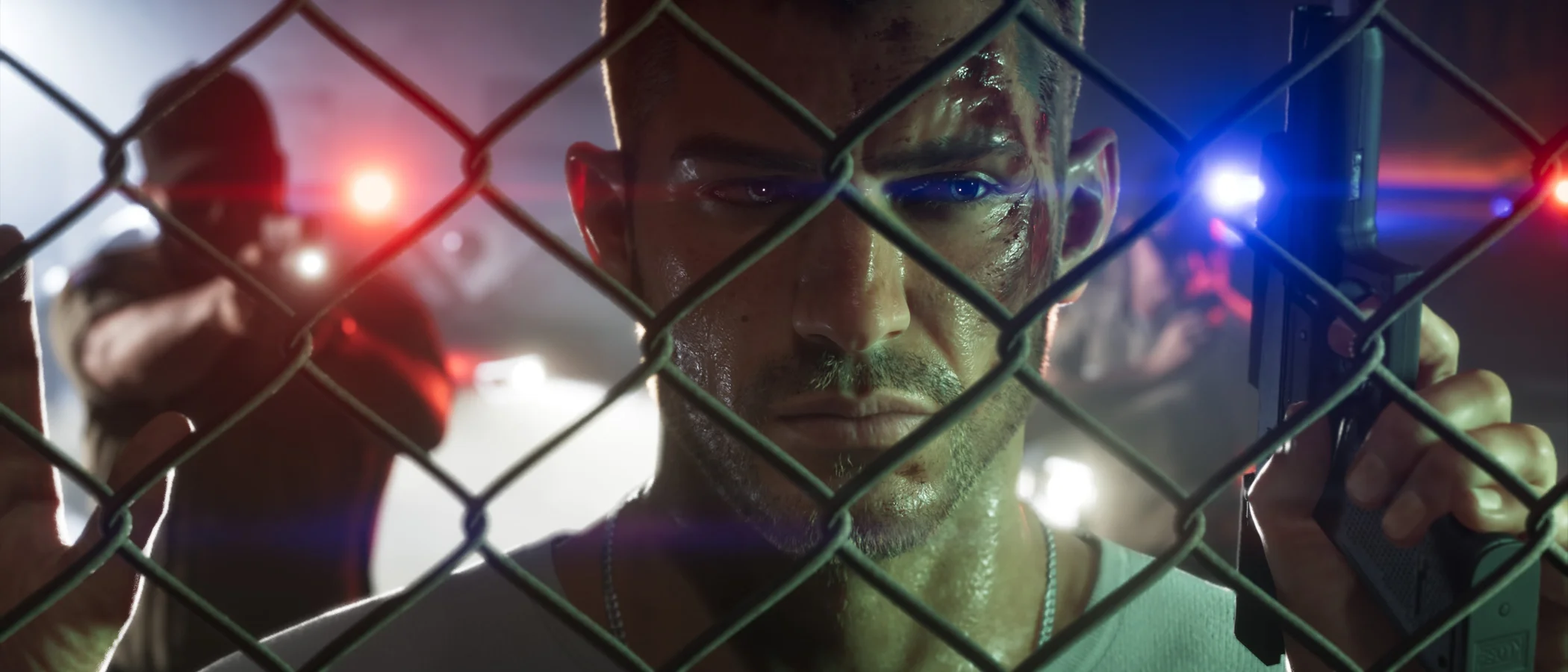 Jason Duval holds a pistol beside a chain-link fence, with police lights behind him.