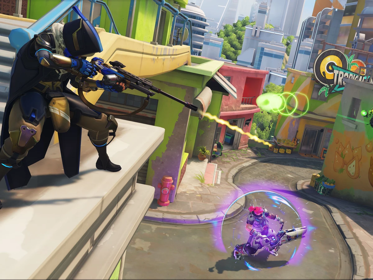 Ana aims her rifle across a street during an Overwatch battle in Rio