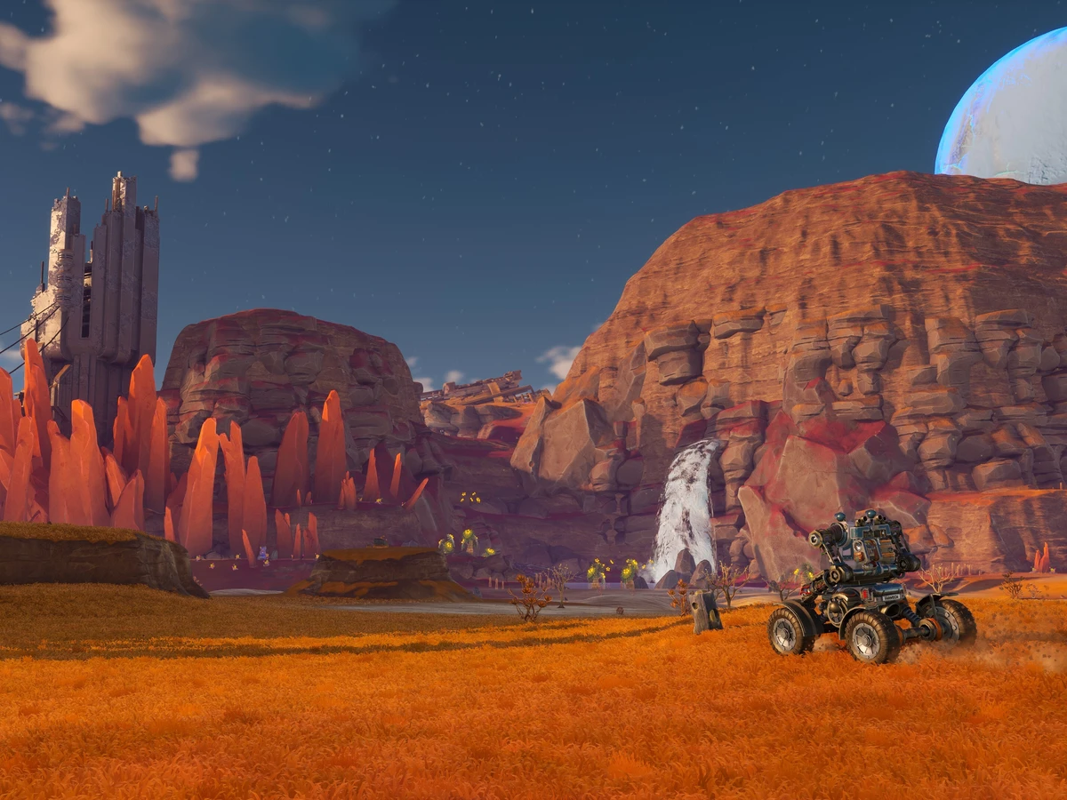 A wheeled mech faces orange crystals, ruined towers and a waterfall in the Sandswept Highlands.